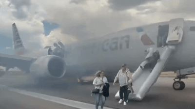 Panic on Denver Airport runway: American Airlines aborts takeoff after gear malfunction; video shows passengers fleeing down slides as smoke engulfs plane